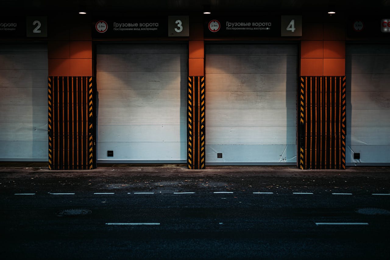 Night view of a modern loading dock with closed garage doors in an urban area, showcasing industrial architecture.